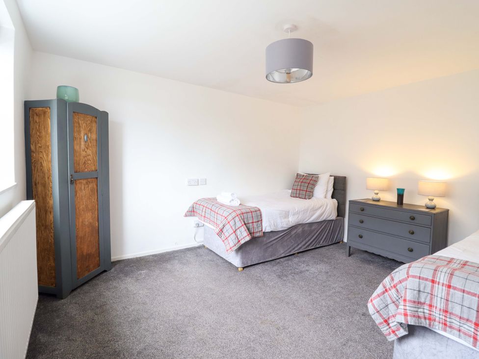 A bedroom with two single beds and a dresser at Glyn Morfa in Harlech