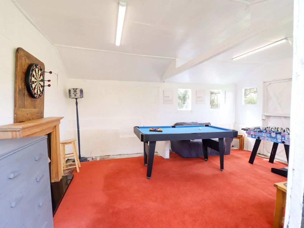 A game room with a pool table and foosball table at Glyn Morfa in Harlech