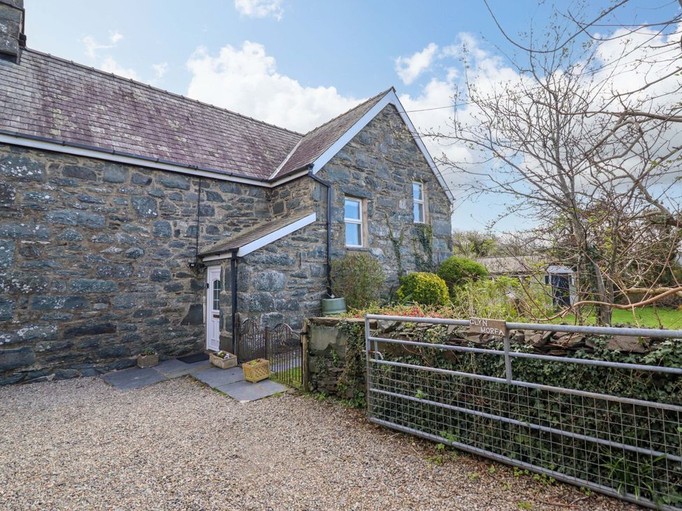 An outdoor view of a stone house and garden at Glyn Morfa in Harlech