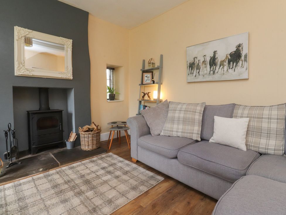 A living room with a couch and fireplace at Glebe Cottage in Broughton near Skipton