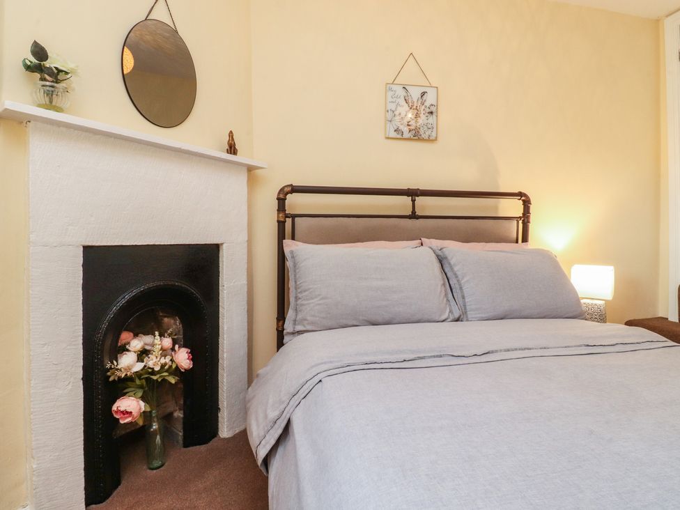 A bedroom with a bed and mirror at Glebe Cottage Broughton near Skipton