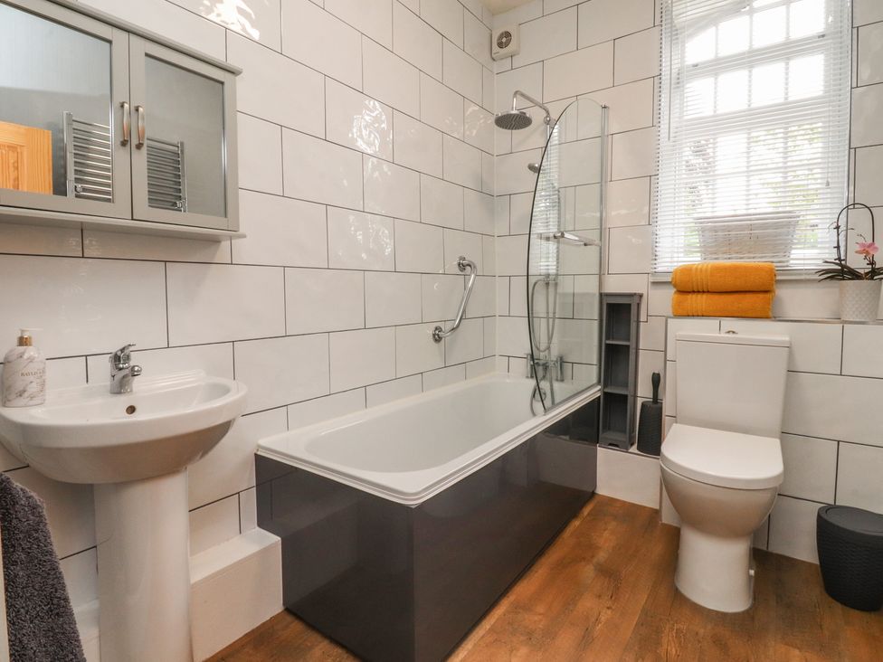 A bathroom with a bathtub, sink, and toilet at Glebe Cottage in Broughton near Skipton