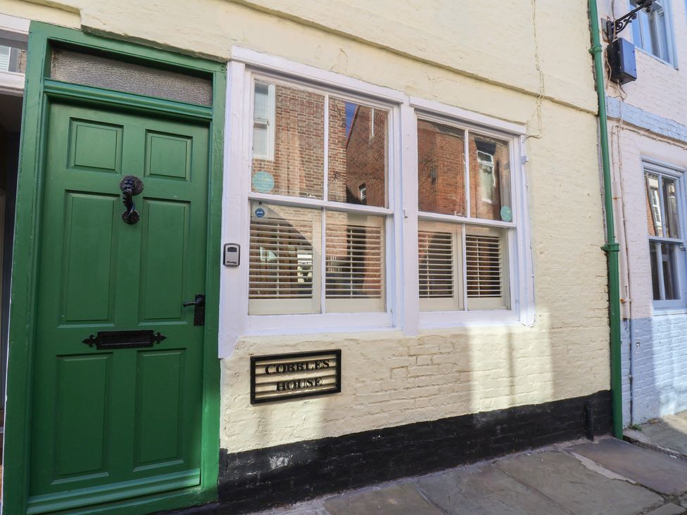 An entrance with a green door and window at Cobbles House in Whitby