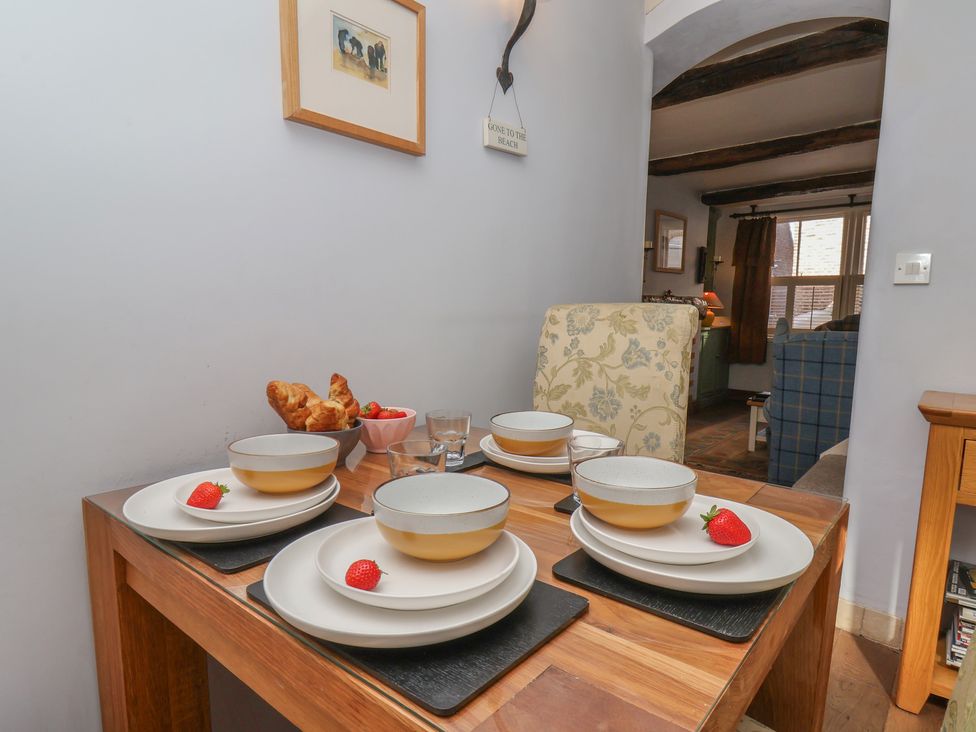 A dining table set with plates and fruits at Cobbles House, Whitby