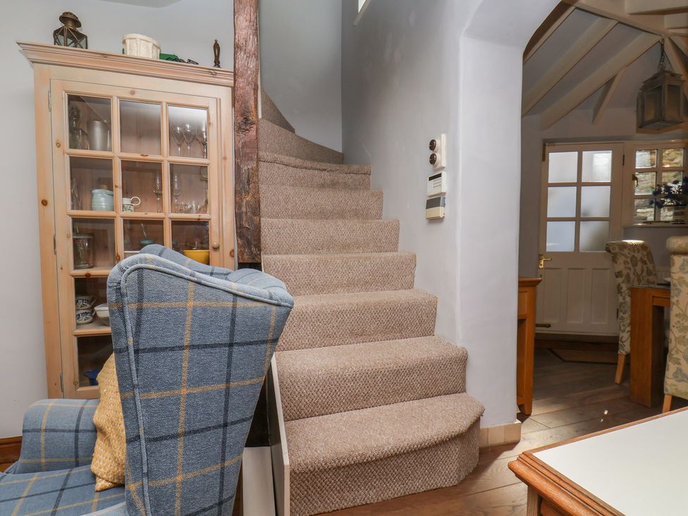A living room with a staircase leading upstairs at Cobbles House in Whitby