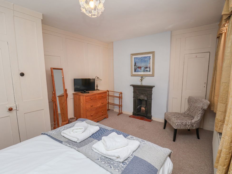 A bedroom with a bed and television at Cobbles House in Whitby