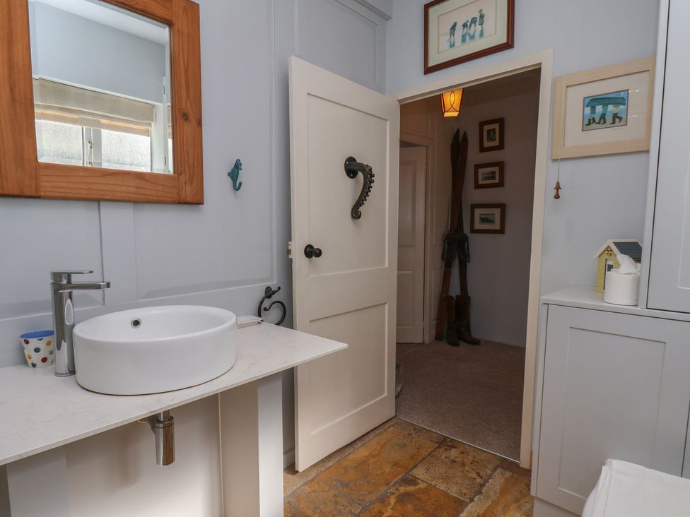 A bathroom with a sink and mirror at Cobbles House in Whitby