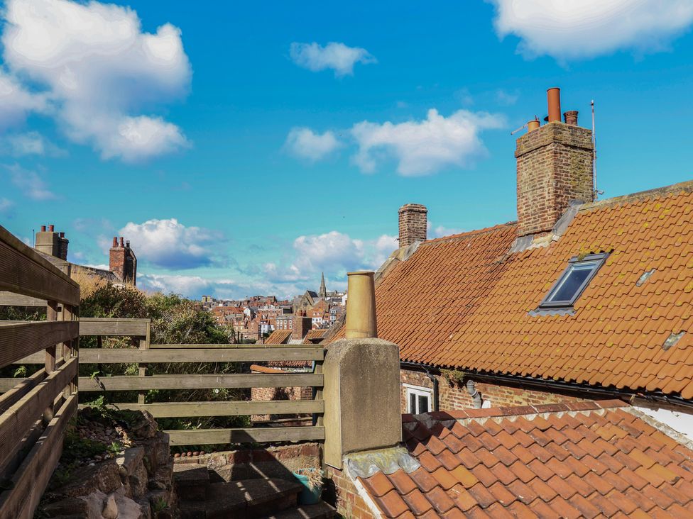 A rooftop view with chimneys and buildings at Cobbles House in Whitby