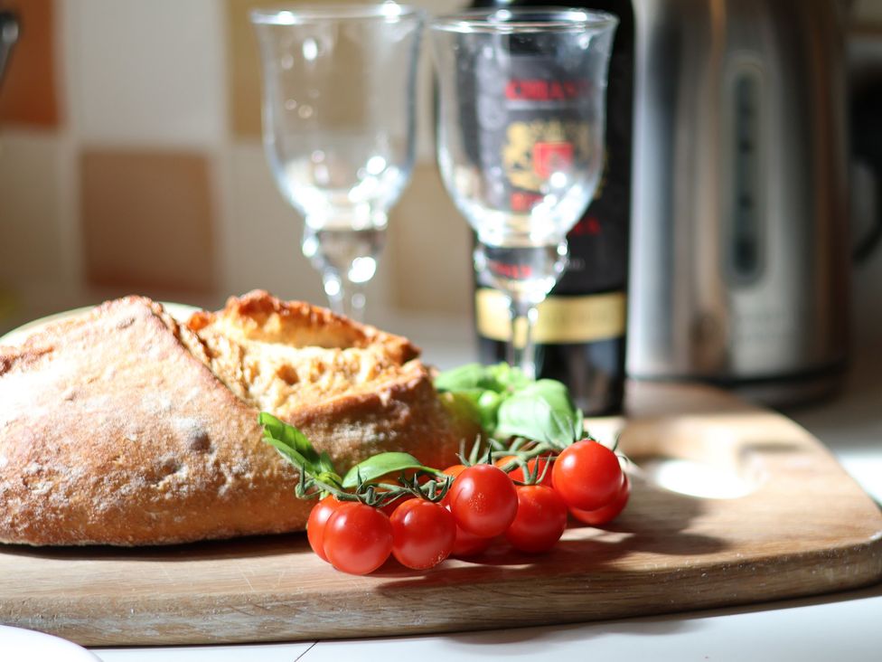 A kitchen scene with bread and tomatoes on a wooden board at Cobbles House in Whitby