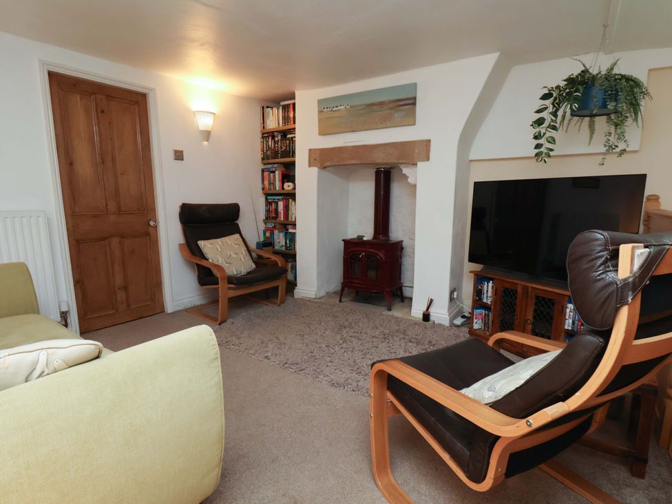 A living room with a chair and a television at Damson Cottage in Whitby
