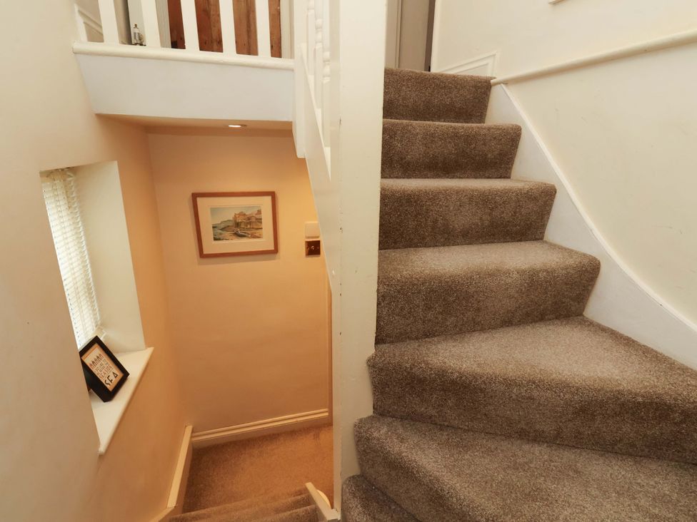 A stairway with a framed picture at Damson Cottage in Whitby