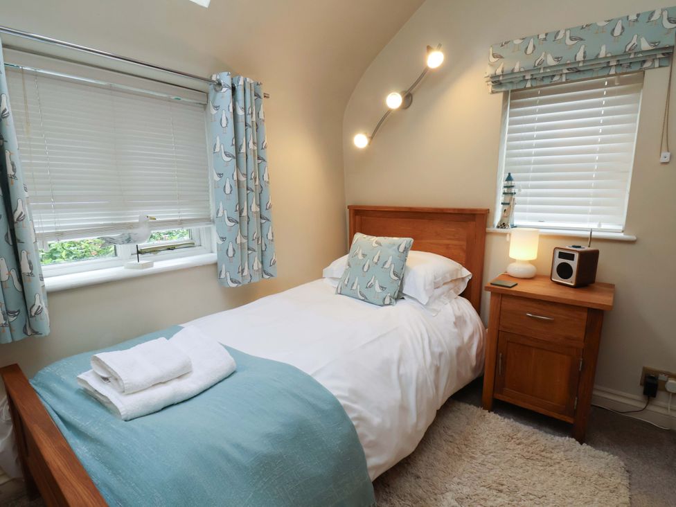 A bedroom with a single bed and nightstand at Damson Cottage in Whitby