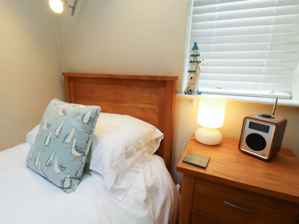 A bedroom with bed and nightstand at Damson Cottage in Whitby