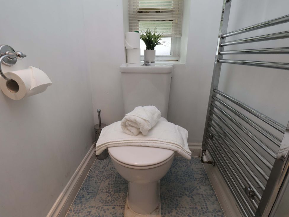 A bathroom with a toilet and towels at Damson Cottage in Whitby