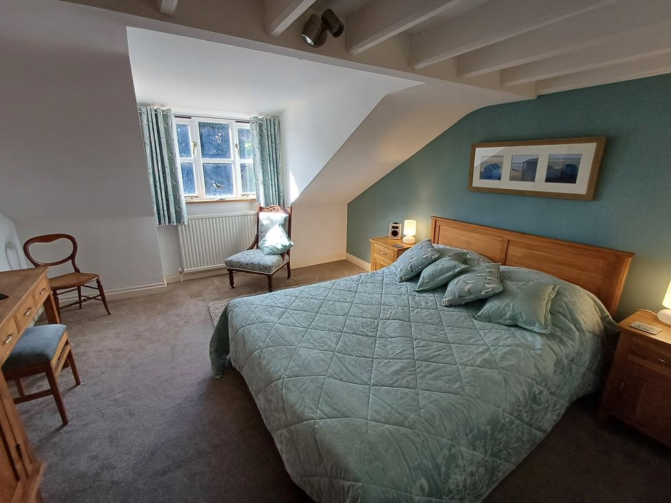 A bedroom with a bed and desk at Damson Cottage in Whitby