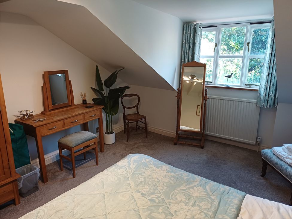 A bedroom with a vanity table and a mirror at Damson Cottage in Whitby