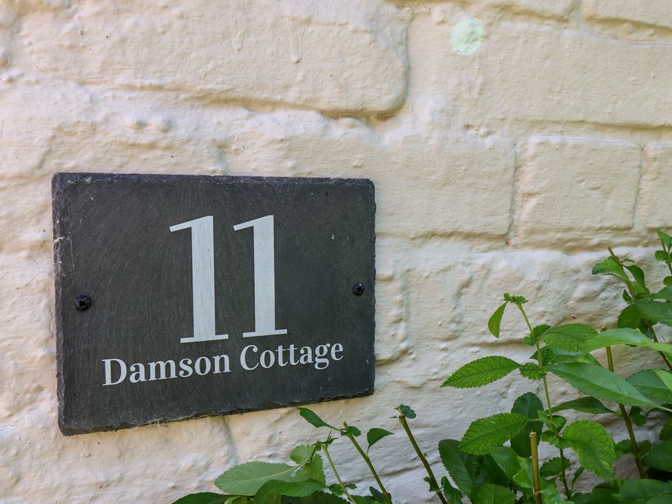 A house number and name plaque on a wall at Damson Cottage in Whitby
