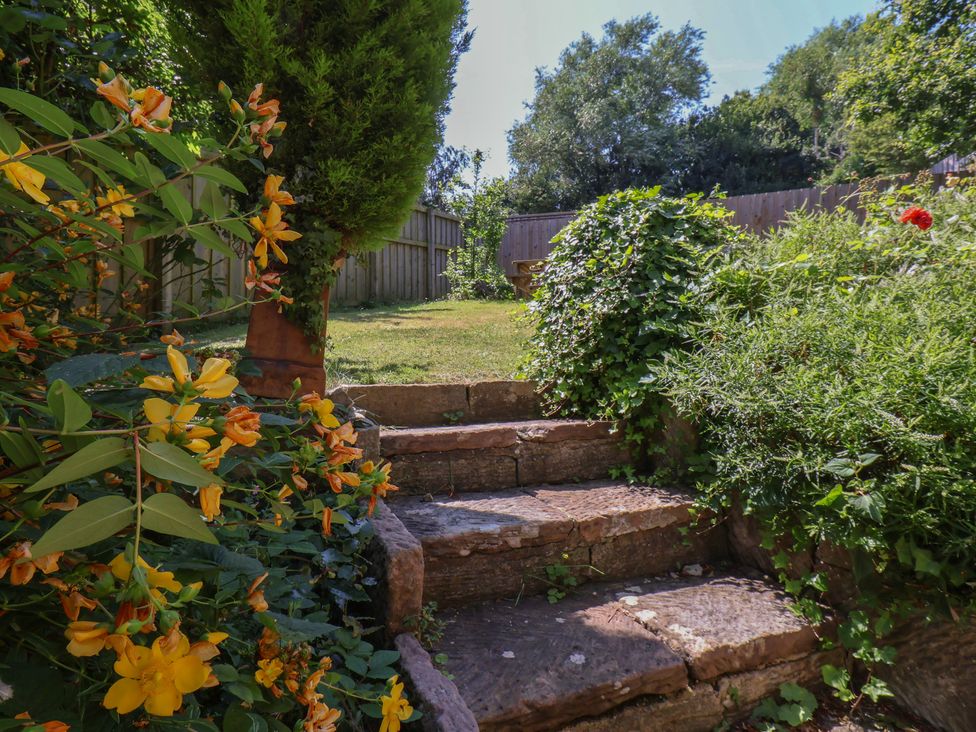 A garden with stone stairs and flowers at Damson Cottage in Whitby