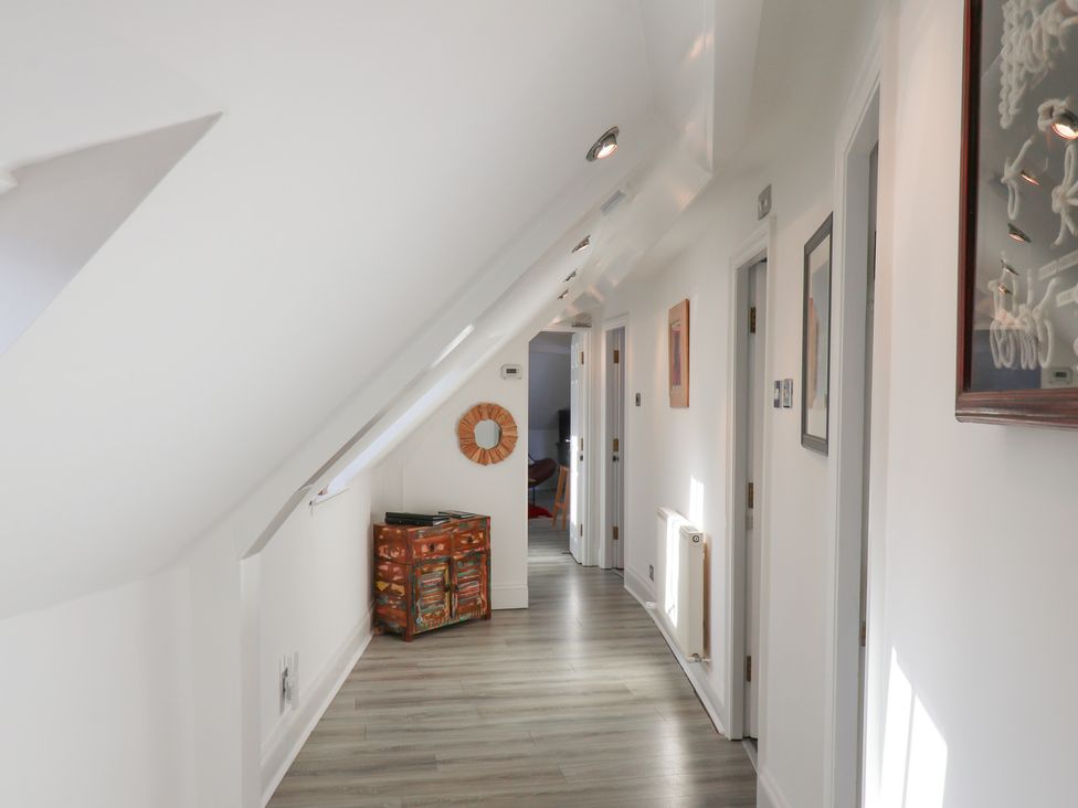 A hallway with doors and paintings at Beachfront in Whitby
