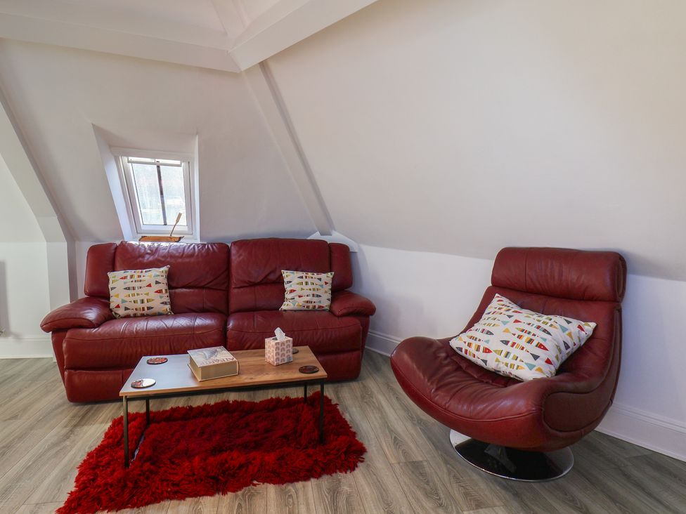 A living room with a couch and armchair at Beachfront in Whitby