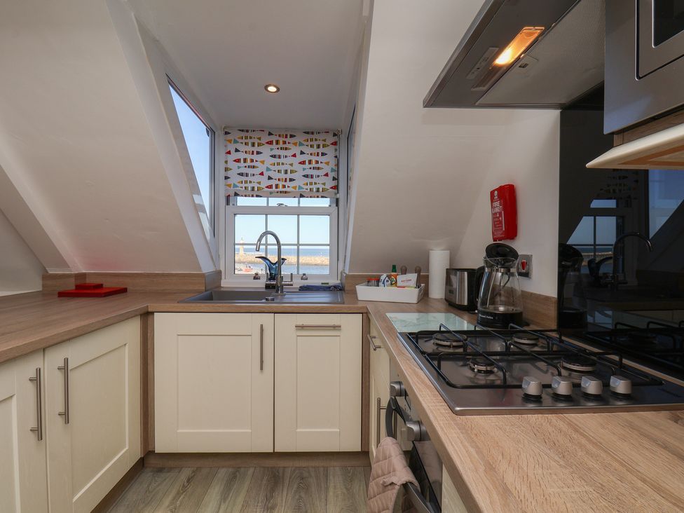 A kitchen with a sink and gas stove at Beachfront in Whitby