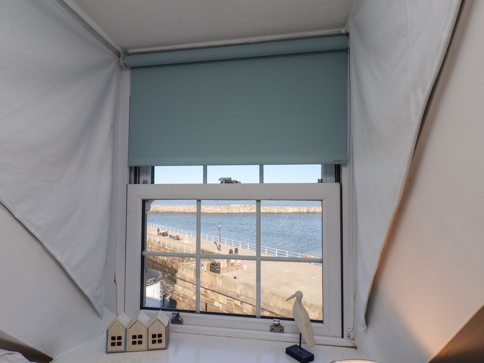 A window with a sea view and decorative items at Beachfront in Whitby