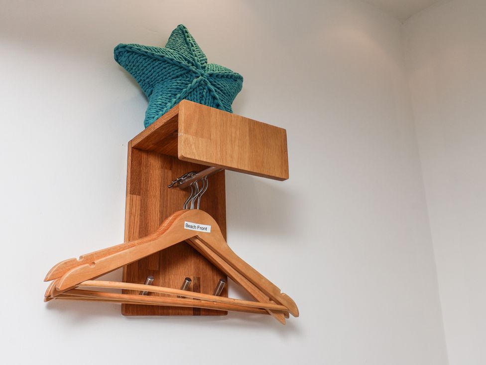 A wooden hanger and shelf with a starfish decoration at Beachfront in Whitby