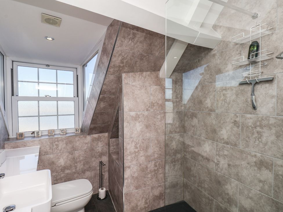 A bathroom with a sink, toilet, and shower at Beachfront in Whitby