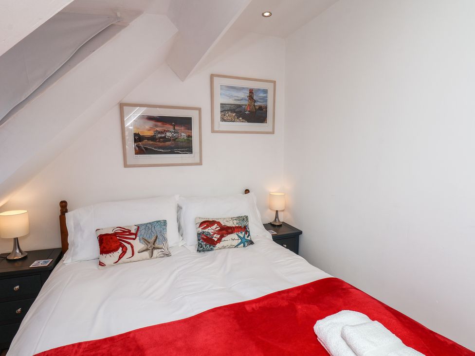 A bedroom with a bed and nightstand at Beachfront in Whitby