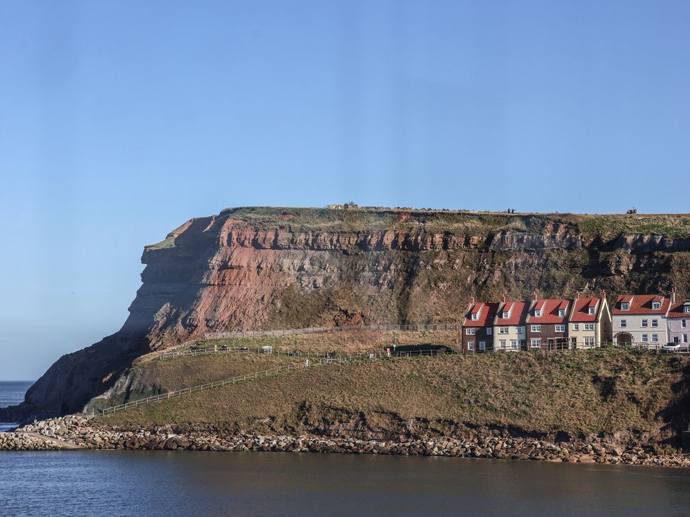 A cliff with houses near the ocean at Beachfront in Whitby