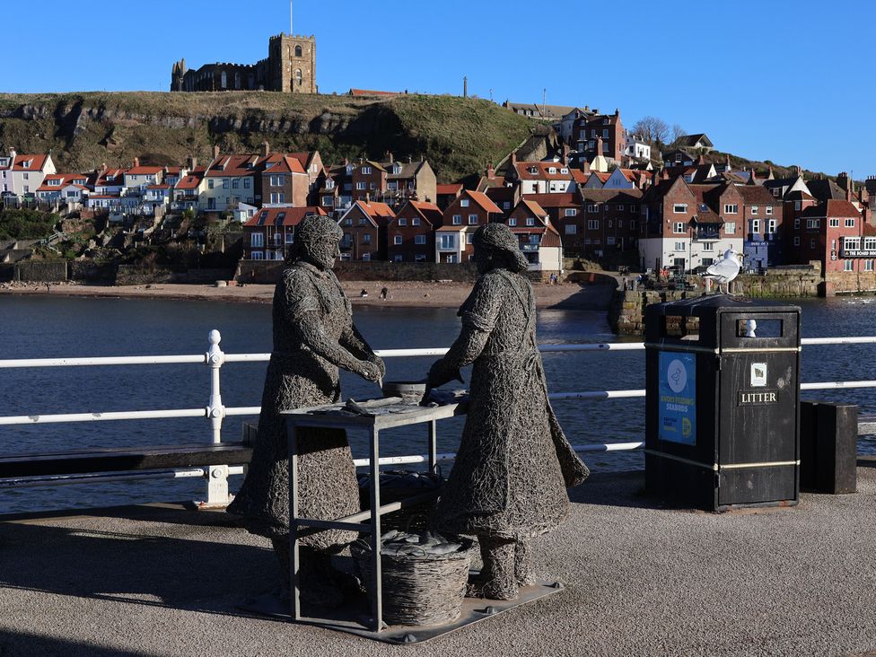 A statue of two figures at a waterfront in Beachfront Whitby