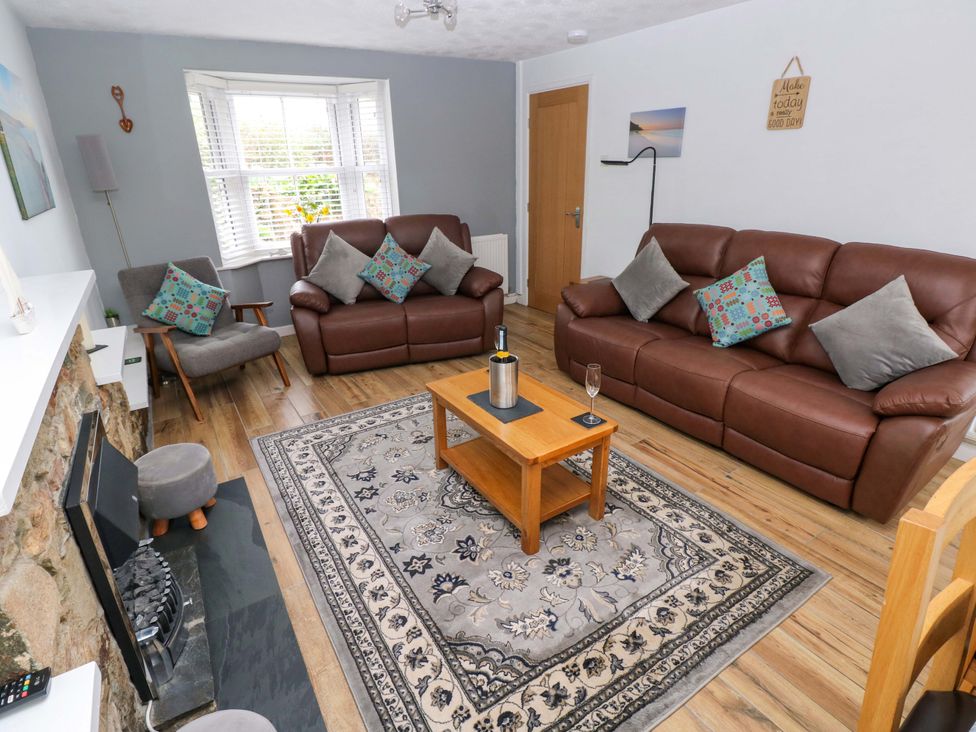 A living room with sofas and a coffee table at Ty'r Winllan in Newport, Pembrokeshire