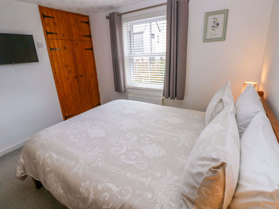 A bedroom with a bed and wardrobe at Ty'r Winllan in Newport, Pembrokeshire
