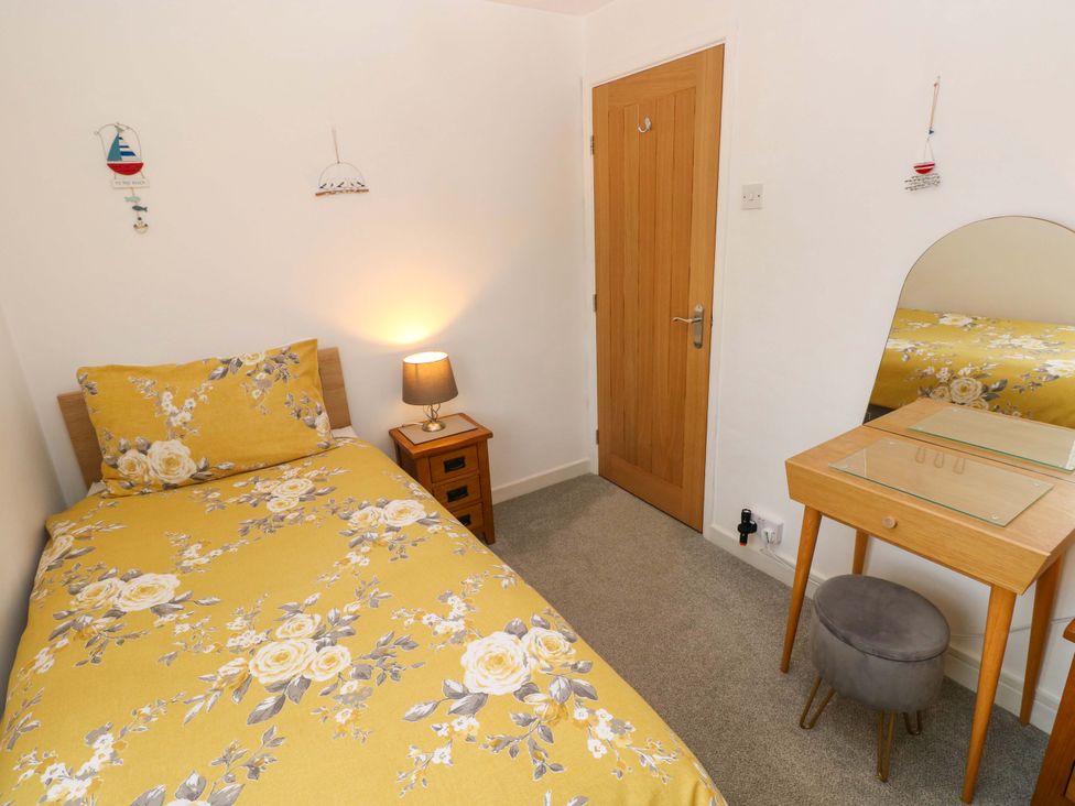 A bedroom with a bed and dressing table at Ty'r Winllan in Newport, Pembrokeshire