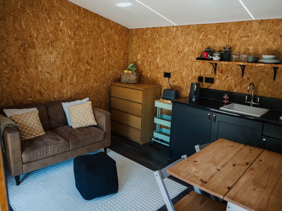 A kitchen with a sofa and storage unit at The Chard in Longtown