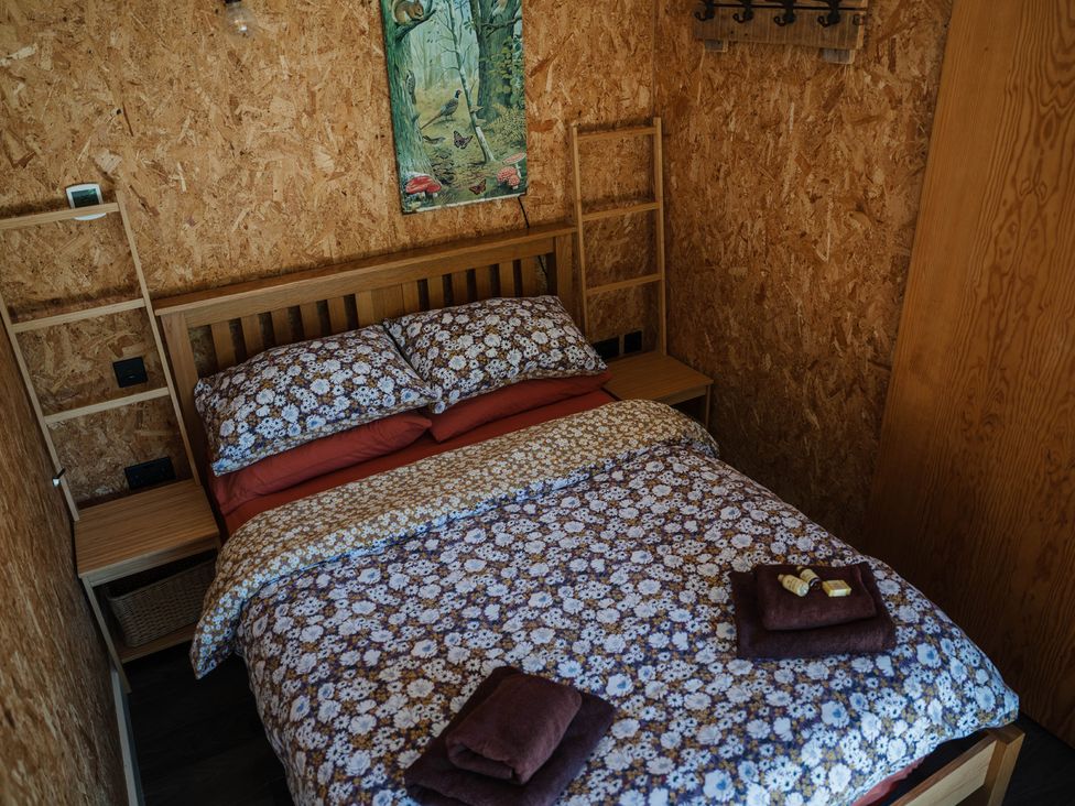 A bedroom with a bed and wooden decor at The Chard in Longtown