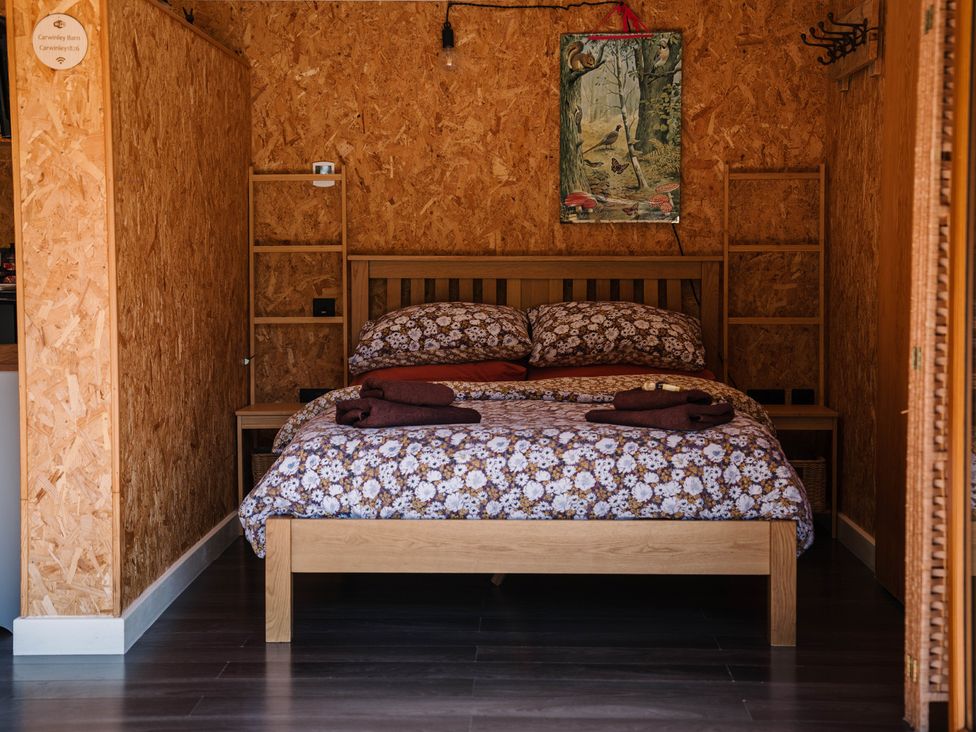 A bedroom with a bed and wooden shelves at The Chard in Longtown
