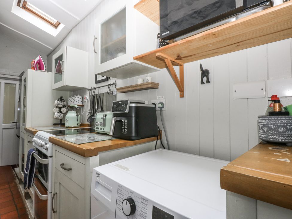 A kitchen with appliances including a washing machine at Tan Yr Allt, Chwilog