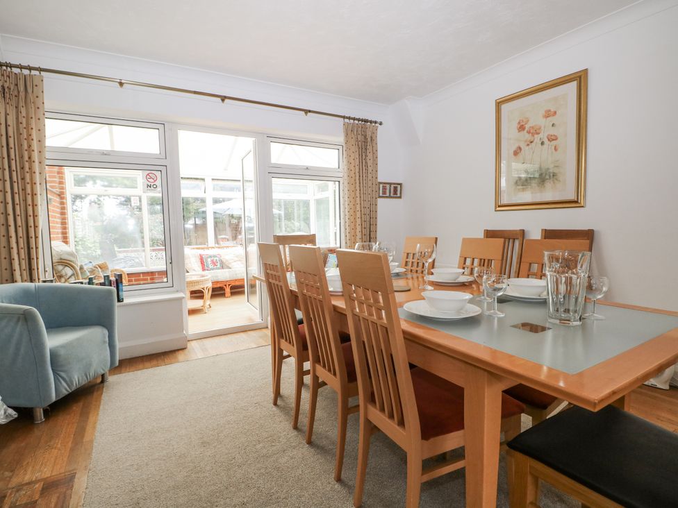 A dining room with a large table set for meals at Sea Dreams in Goring-By-Sea