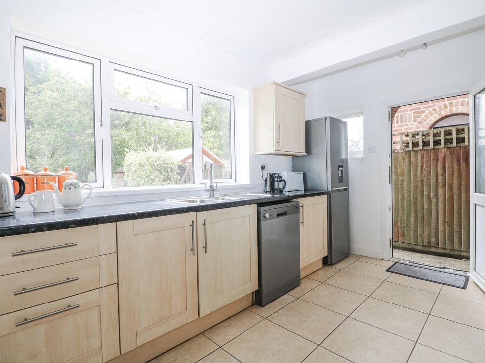 A kitchen with a sink and fridge at Sea Dreams in Goring-By-Sea