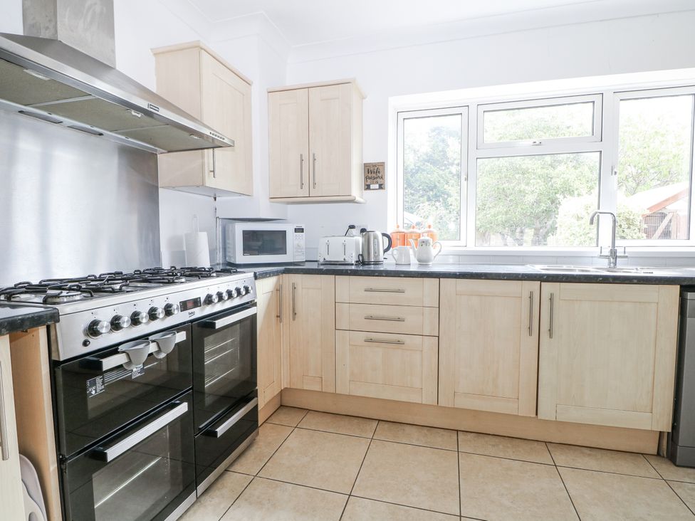 A kitchen with cabinets, oven, stove, and microwave at Sea Dreams in Goring-By-Sea
