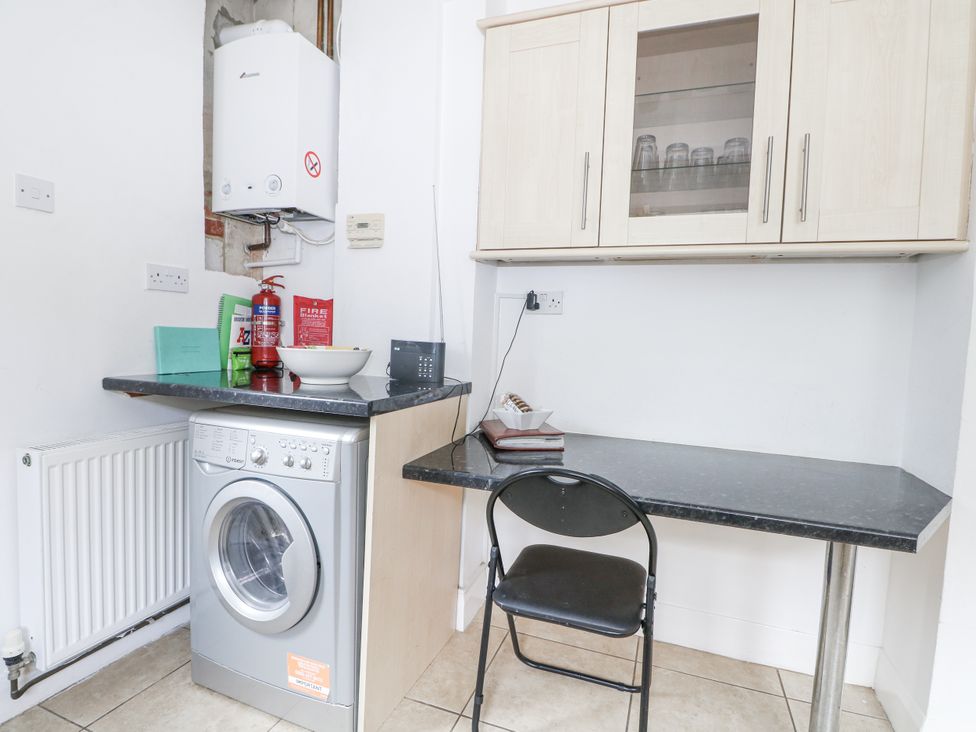 A laundry room with a washing machine and a table at Sea Dreams in Goring-By-Sea