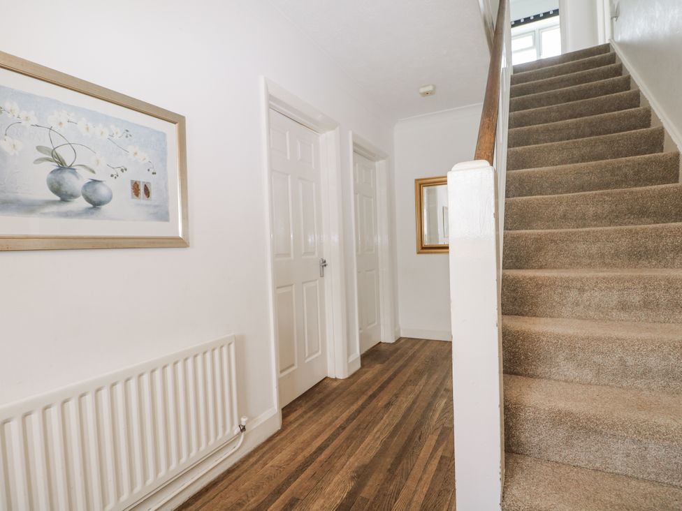 A hallway with a staircase and doors at Sea Dreams in Goring-By-Sea