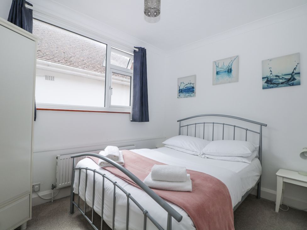 A bedroom with a bed and a wardrobe at Sea Dreams in Goring-By-Sea