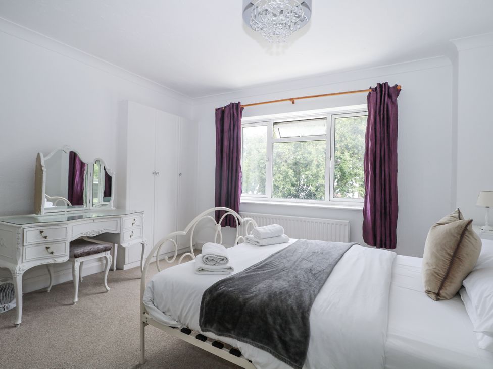 A bedroom with a bed and dressing table at Sea Dreams in Goring-By-Sea
