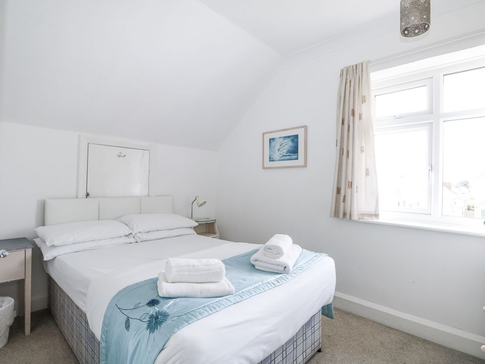 A bedroom with a bed and a bedside table at Sea Dreams in Goring-By-Sea