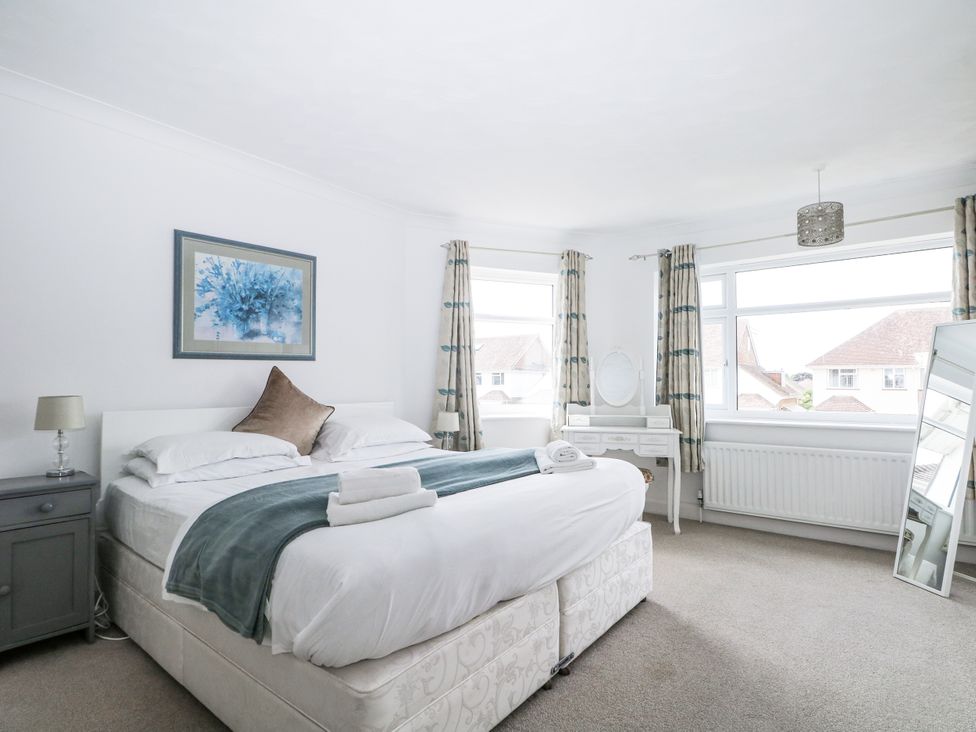 A bedroom with a bed and side table at Sea Dreams in Goring-By-Sea