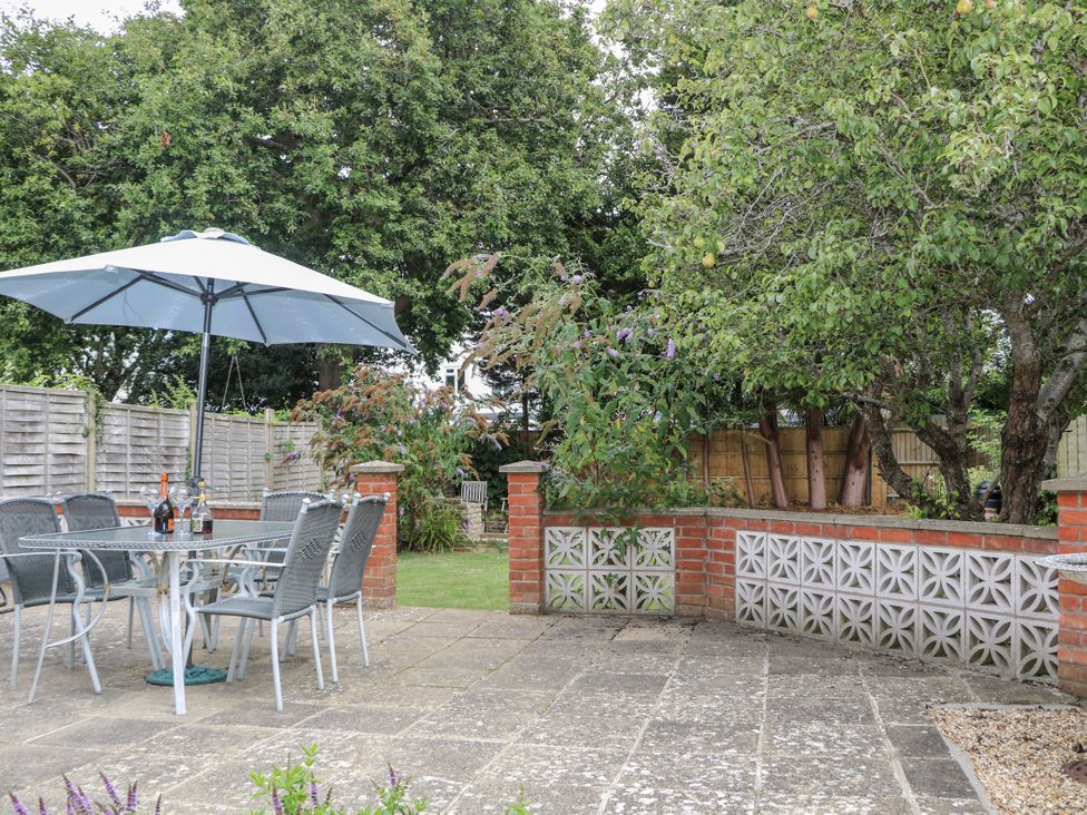 A garden with table and chairs under an umbrella at Sea Dreams in Goring-By-Sea