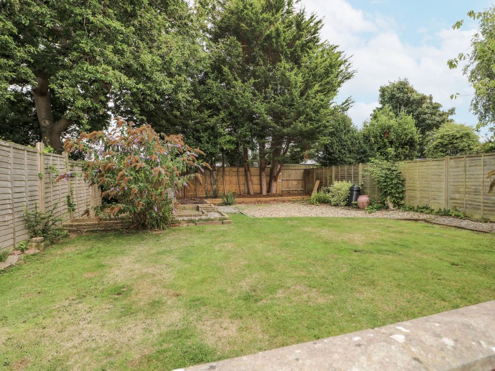 A garden with grass and trees at Sea Dreams in Goring-By-Sea