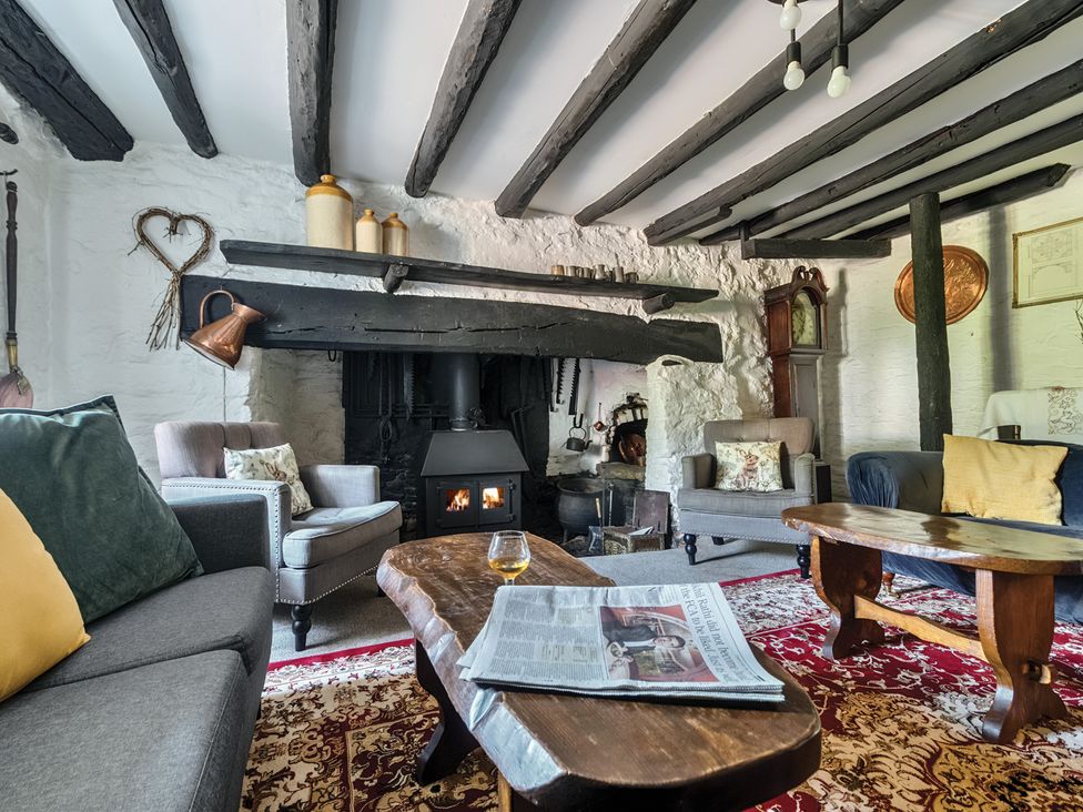 A living room with a fireplace and seating arrangements at The Old Church House in Torbryan